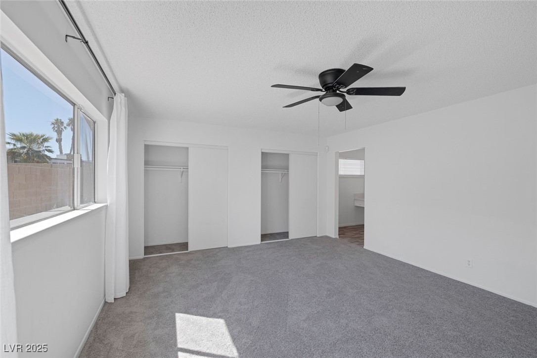 720 Sam Jonas Drive Las Vegas, NV 89145 - Photo 19 of 34 Unfurnished bedroom featuring two closets, a textu