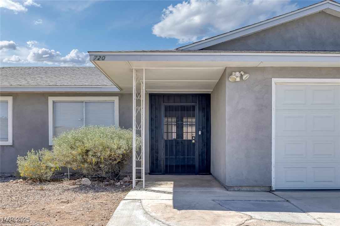 720 Sam Jonas Drive Las Vegas, NV 89145 - Photo 3 of 34 View of exterior entry with a garage, roof with sh