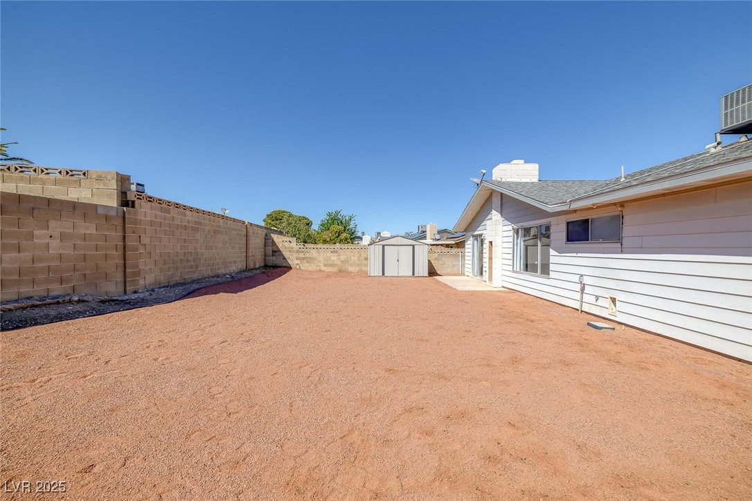 720 Sam Jonas Drive Las Vegas, NV 89145 - Photo 33 of 34 View of yard with a fenced backyard, an outbuildin
