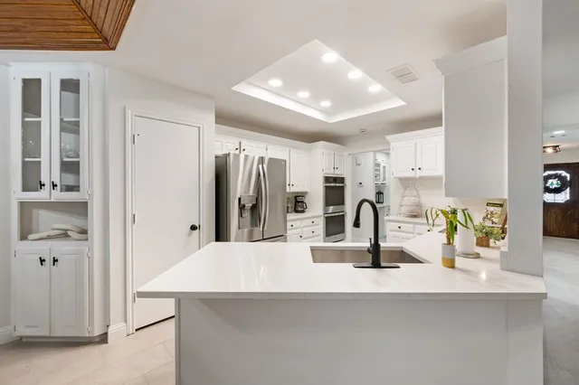 a kitchen with a sink a counter space and cabinets