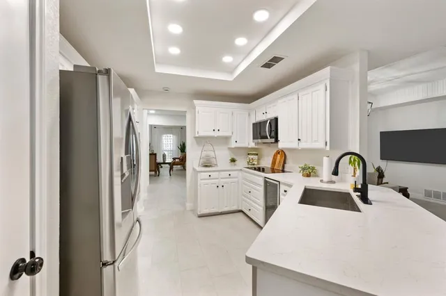 a kitchen with white cabinets and stainless steel appliances