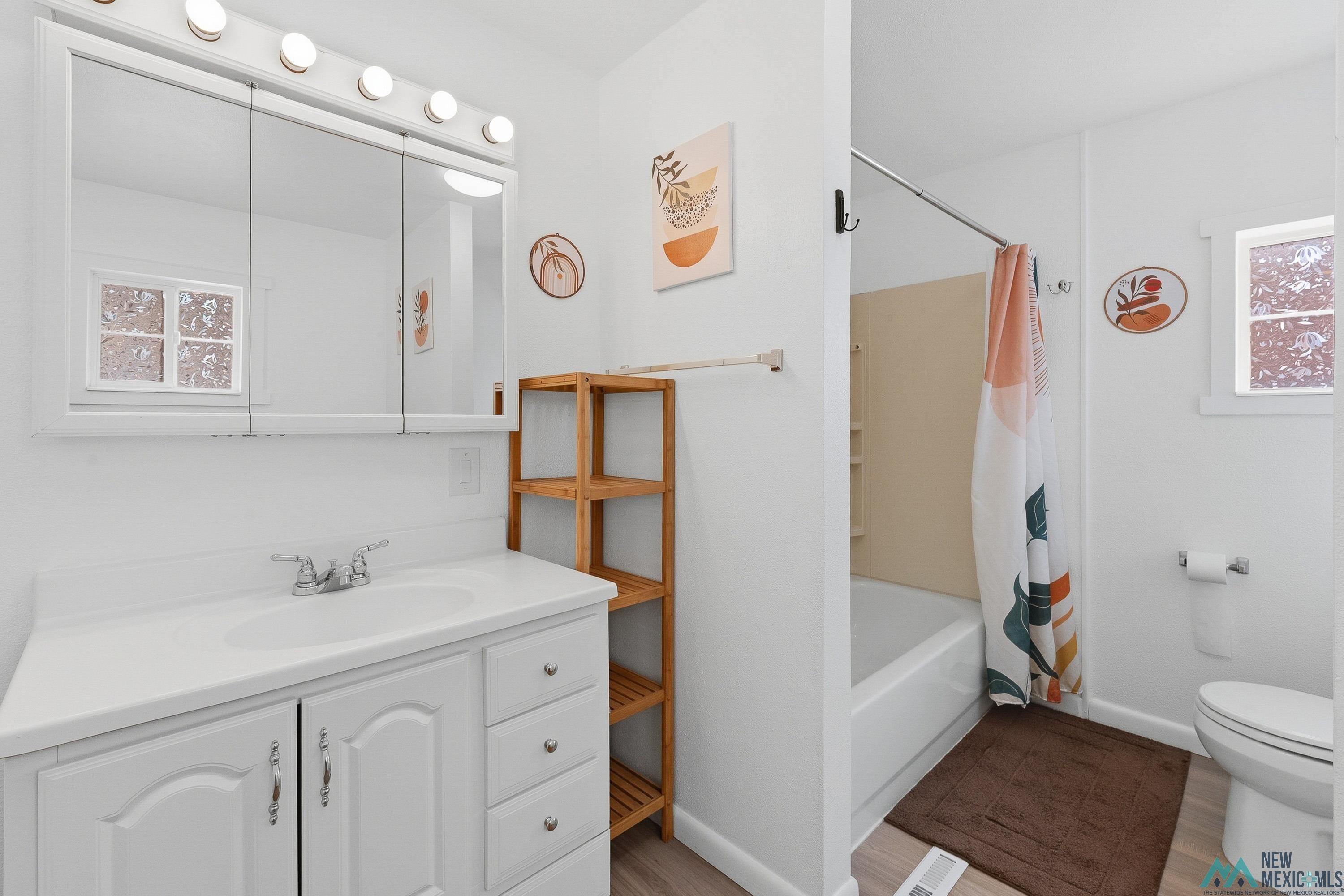 120 South 5th Street Raton, NM 87740 - Photo 16 of 25 Bathroom with vanity, shower / tub combo, and light wood finished floors