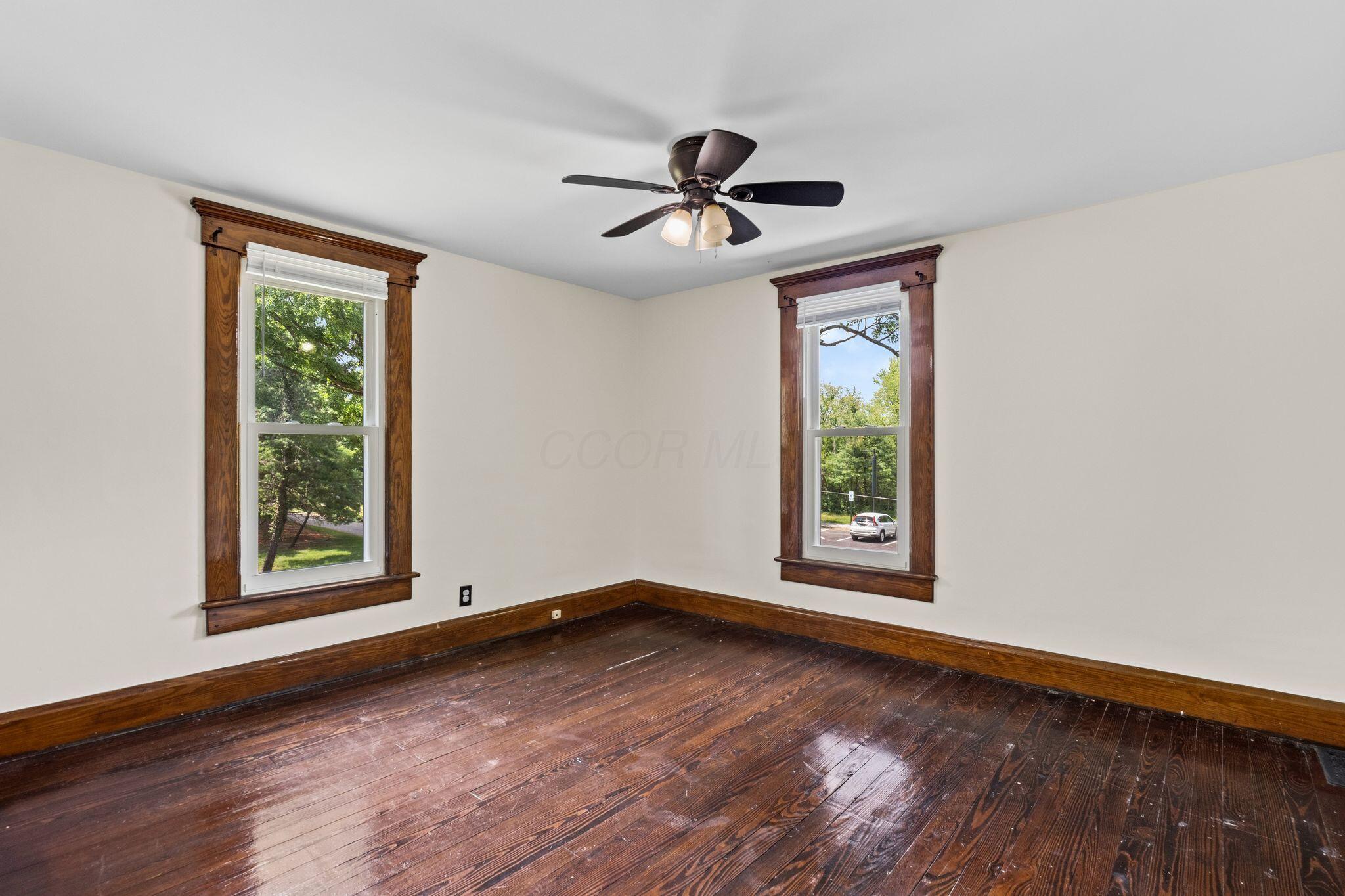 107 Price Road Columbus, OH 43230 - Photo 26 of 51 Room featuring two windows with wood-finish trim, a ceiling fan with light fixture, and wood-finish flooring