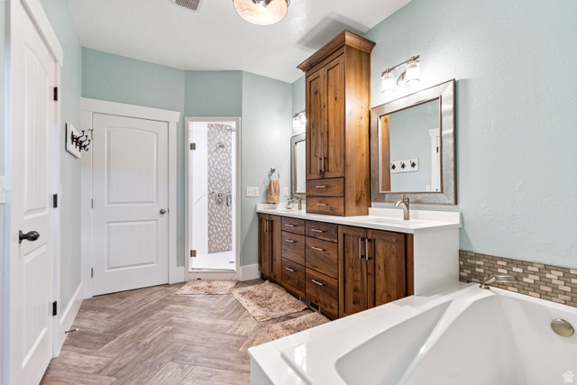 580 Cherry Ridge Lane Richmond, UT 84333 - Photo 19 of 53 Master bath with double vanity, a bath, parquet flooring, and a shower stall
