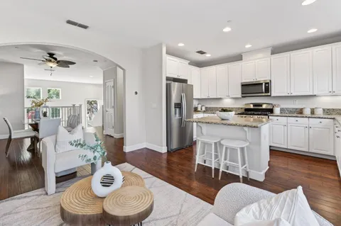 a kitchen with stainless steel appliances kitchen island granite countertop a kitchen island a stove a table and chairs