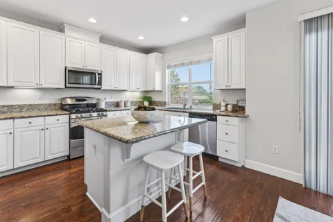 a kitchen with a sink a microwave and cabinets