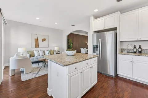 a kitchen with granite countertop white cabinets and stainless steel appliances