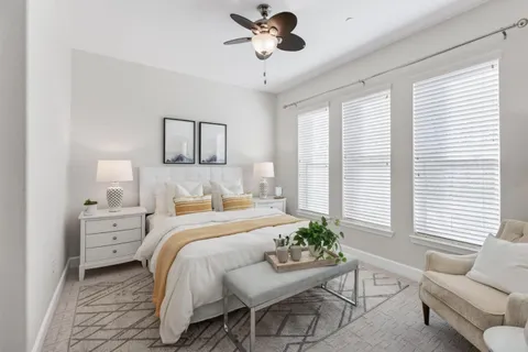 a bedroom with a bed and windows