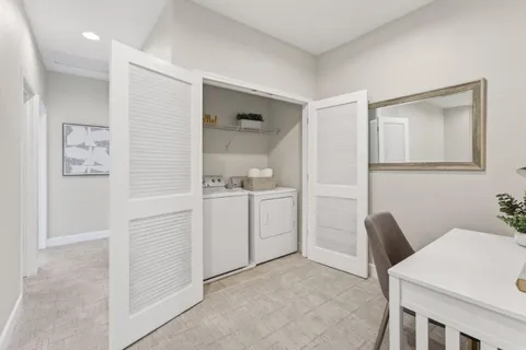 a view of kitchen with refrigerator and white cabinets
