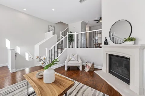 a living room with furniture a fireplace and wooden floor