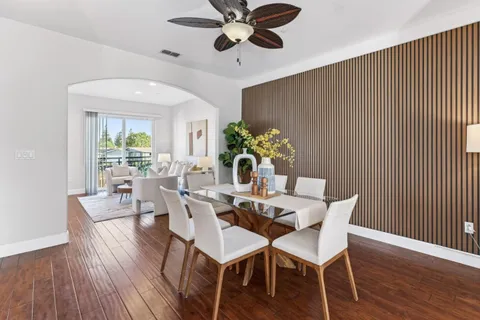 a dining room with furniture potted plants and wooden floor