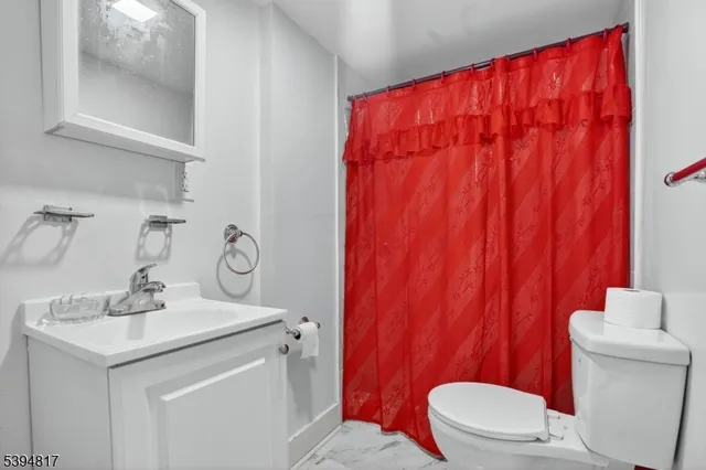 a bathroom with a sink a toilet and shower curtain