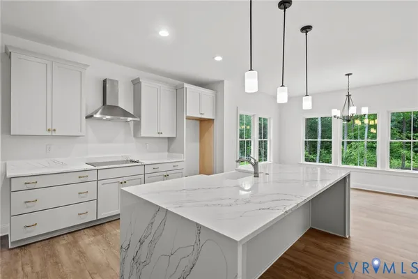 a kitchen with stainless steel appliances granite countertop a sink a stove and a wooden floors