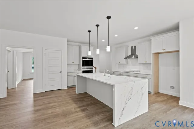 a large kitchen with white cabinets stainless steel appliances and wooden floor