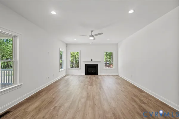 an empty room with windows and a fireplace