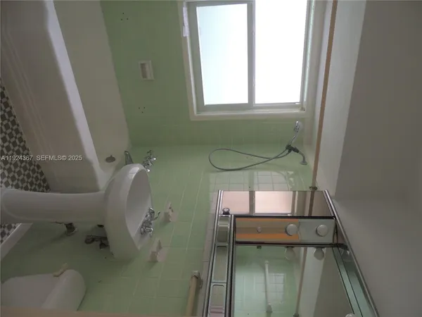 a bathroom with a sink toilet and window