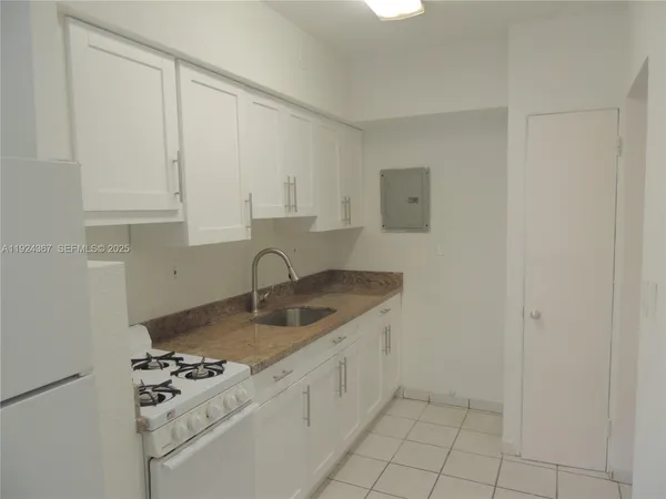 a kitchen with appliances a sink and cabinets