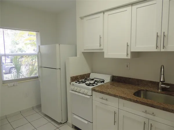 a kitchen with appliances a sink and cabinets