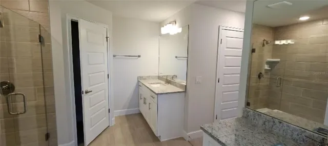 a bathroom with a granite countertop shower mirror and a sink