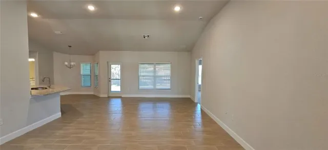 a view of an empty room with a fireplace and wooden floor
