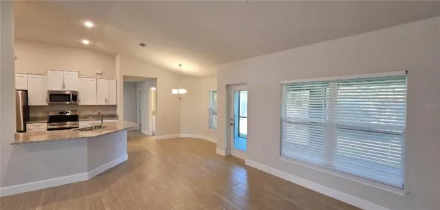 a view of a kitchen with a sink a refrigerator and window