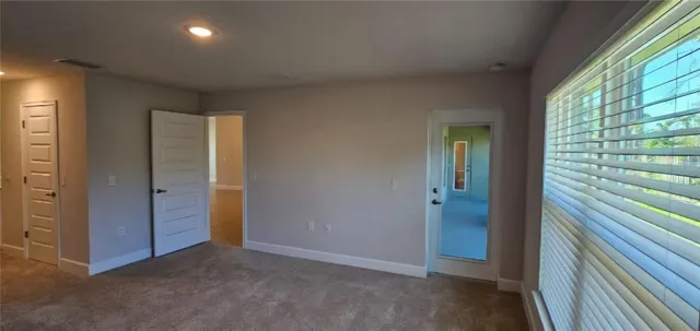 an empty room with windows and closet