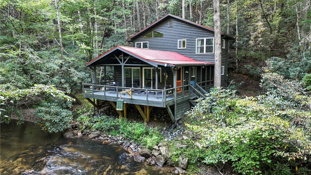 129 Old Bend Road Blue Ridge, GA 30513 - Photo 44 of 44 a backyard of a house with table and chairs under an umbrella