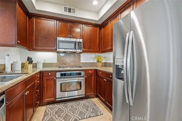a kitchen with stainless steel appliances granite countertop a refrigerator sink and cabinets