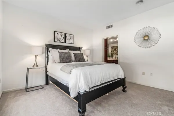 a bed sitting in a bedroom and painting on the wall