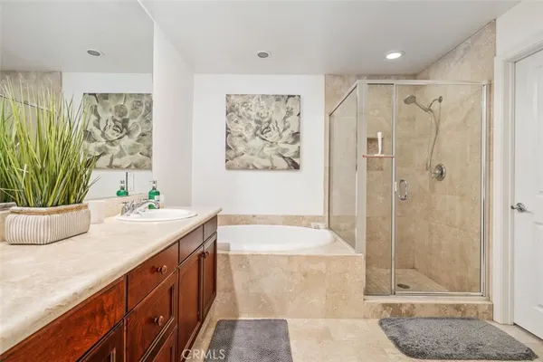 a bathroom with a granite countertop sink a mirror a bathtub and shower
