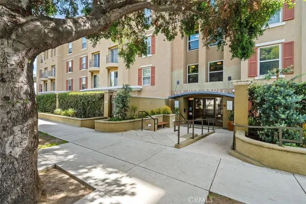 a view of a building with sitting area and garden