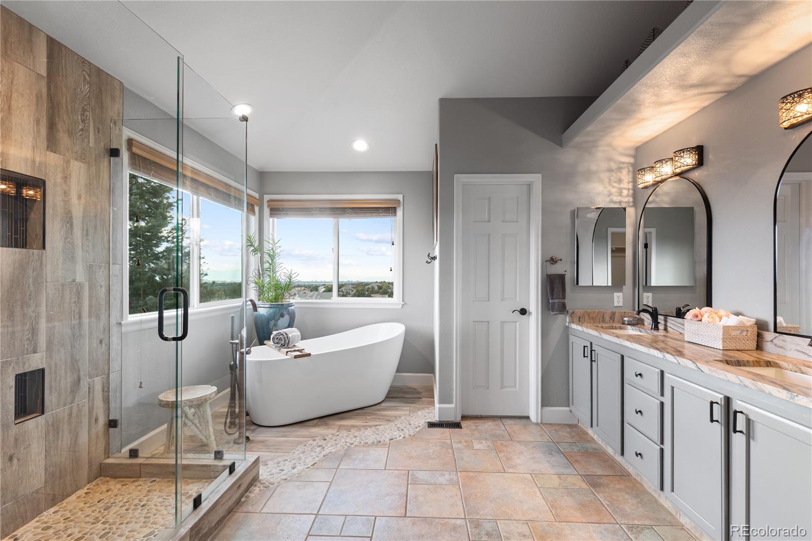6261 South Sicily Way Aurora, CO 80016 - Photo 32 of 50 a spacious bathroom with a double vanity sink a mirror and a bathtub