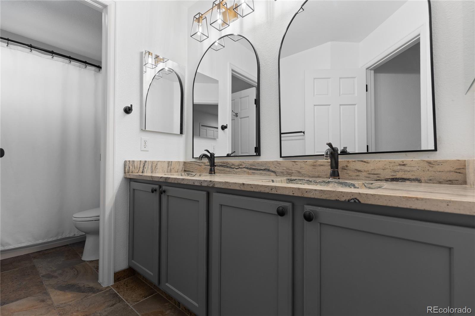 6261 South Sicily Way Aurora, CO 80016 - Photo 38 of 50 a bathroom with a granite countertop toilet sink and mirror