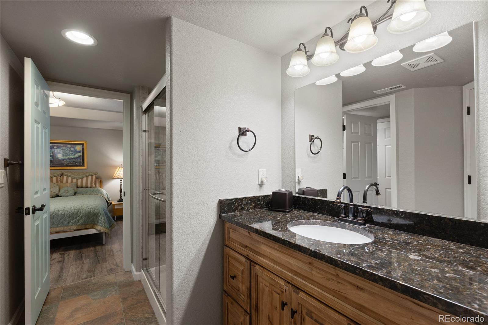 6261 South Sicily Way Aurora, CO 80016 - Photo 45 of 50 a en suite bathroom with a granite countertop sink and a mirror