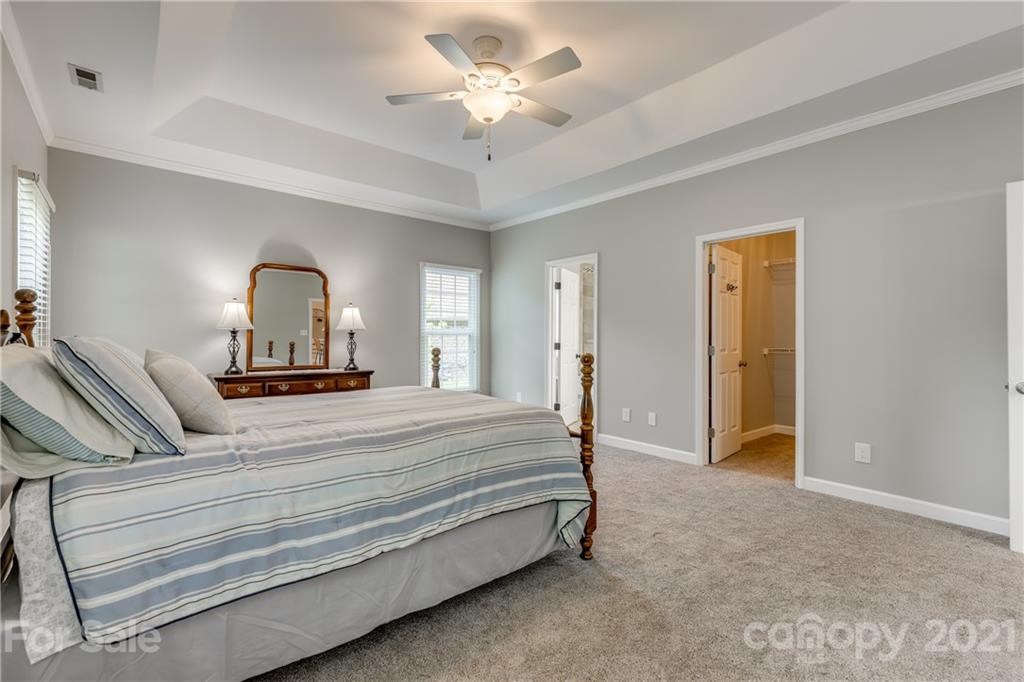 305 Savannah Lane Fort Mill, SC 29708 - Photo 21 of 46 a bedroom with a bed and a chandelier