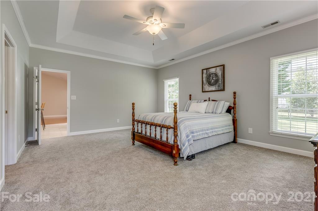 305 Savannah Lane Fort Mill, SC 29708 - Photo 22 of 46 a spacious bedroom with a bed and a chandelier
