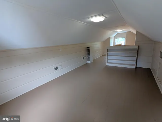 an empty room with windows and wooden floor