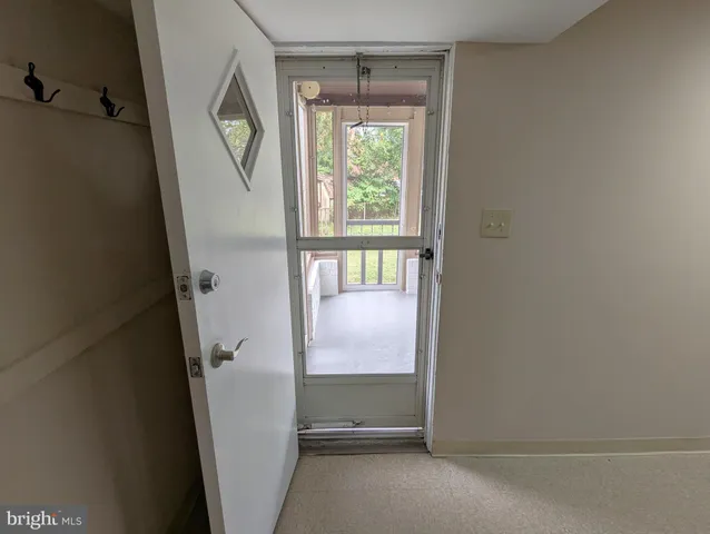 a view of empty room with wooden floor and windows