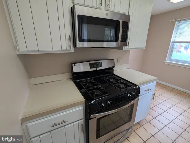 a stove top oven sitting inside of a kitchen