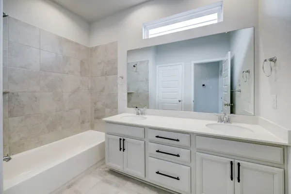 a bathroom with a tub sink and mirror