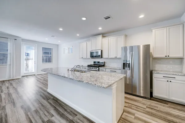 a kitchen with stainless steel appliances granite countertop a sink stove and refrigerator
