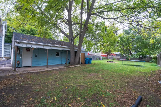 a view of backyard with large trees and wooden fence