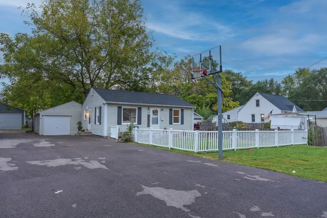 a view of a house with a yard and large tree