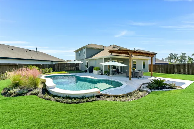 a view of a house with swimming pool and a yard