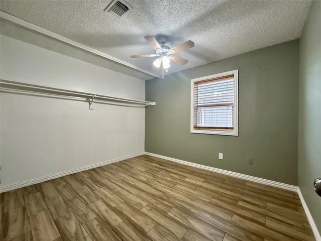 an empty room and chandelier fan