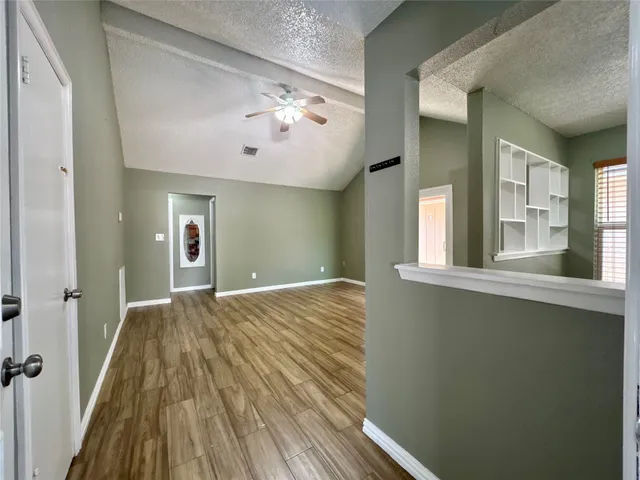a view of a livingroom with wooden floor and staircase