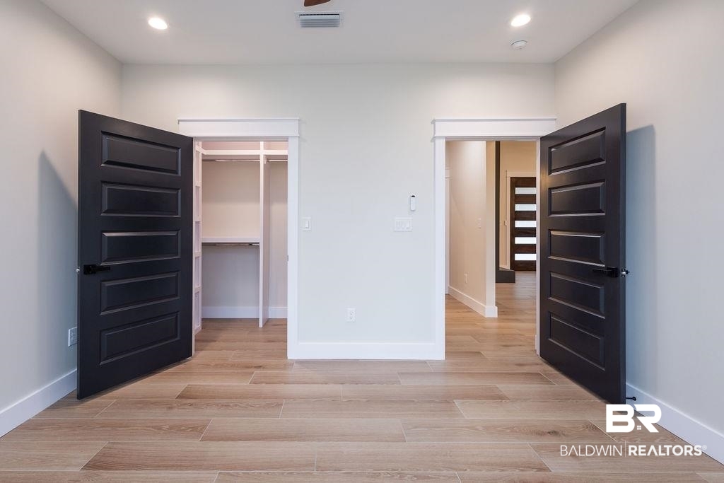 13066 Gopher Court Elberta, AL 36530 - Photo 18 of 38 Interior space featuring wood-finish flooring, recessed lighting, and a built-in closet with shelving and hanging space