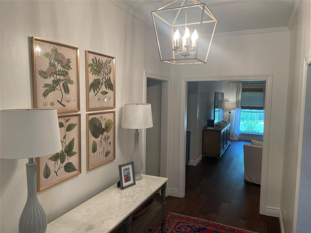 4301 Winding Way Benbrook, TX 76126 - Photo 5 of 25 Hallway with crown molding, dark wood-style floors, and a chandelier