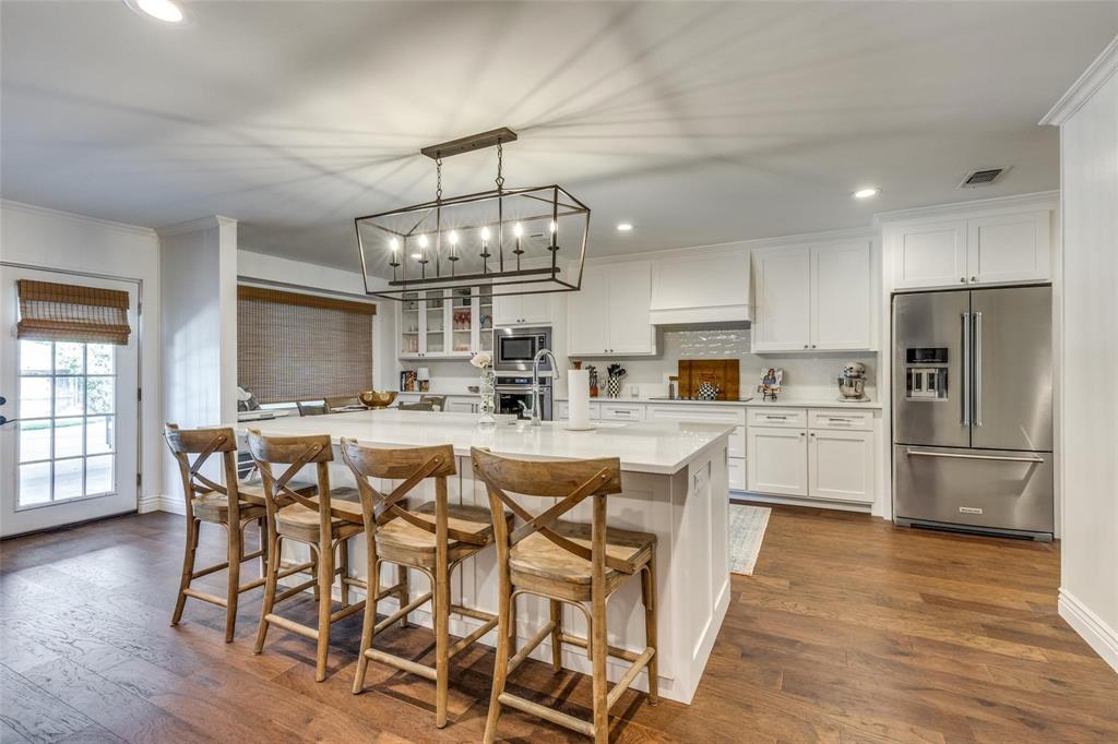 4301 Winding Way Benbrook, TX 76126 - Photo 8 of 25 Kitchen with recessed lighting, white cabinets, a kitchen breakfast bar, appliances with stainless steel finishes, and dark wood-type flooring