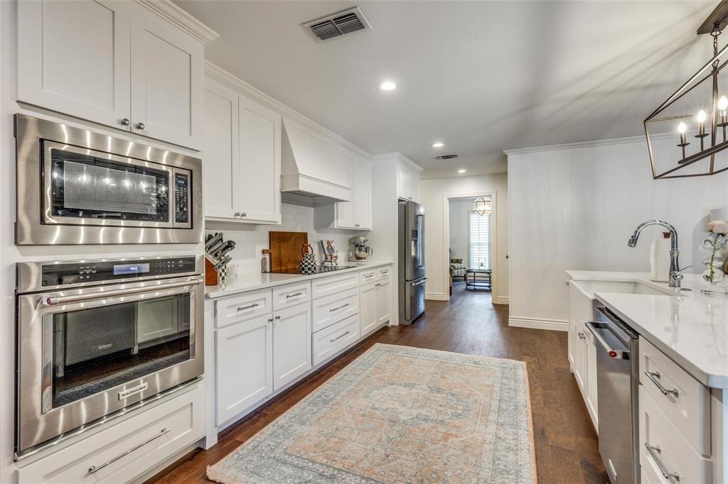 4301 Winding Way Benbrook, TX 76126 - Photo 10 of 25 Kitchen with stainless steel appliances, white cabinets, recessed lighting, premium range hood, and light stone counters
